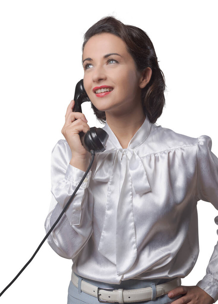 Attractive elegant vintage secretary having a phone call and smiling - Foto, afbeelding