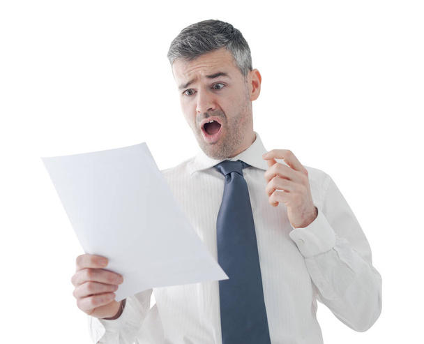Businessman in the office receiving shocking bills and tax documents, he is gasping and screaming - 写真・画像