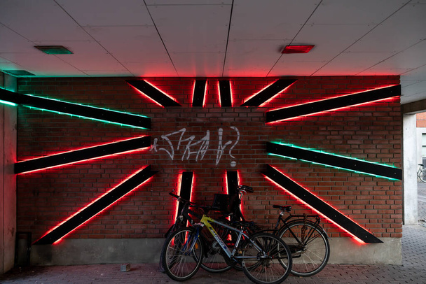 Κοπεγχάγη, Δανία Ένα νέον φώτα όμορφα πλαισιώνει μια σειρά από σταθμευμένα ποδήλατα eraly το πρωί στην περιοχή Norrebro. - Φωτογραφία, εικόνα