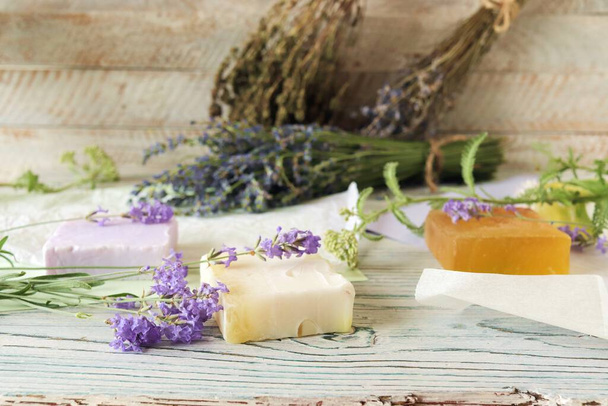 Lavender flowers, soap, oils and tinctures, on a wooden background, natural ingredients, alternative medicine - Foto, imagen