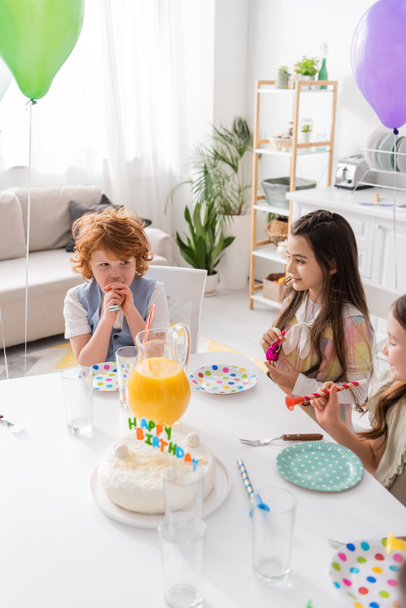 high angle view of cheerful kids holding party horns during birthday at home  - Fotografie, Obrázek