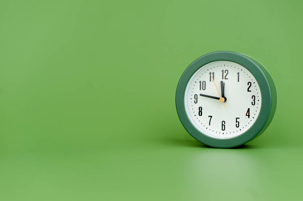 réveil sur fond vert concept de temps de travail avec le temps temps précieux - Photo, image