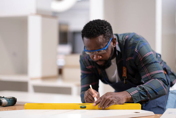 Konzentrieren Sie sich auf afroamerikanische Arbeiter Hand verwenden Wasseruhr und Bleistift, Mitarbeiter macht seine Arbeit seriös, professionell und ordentlich. - Foto, Bild