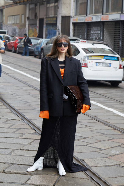 MILAN, ITALY - FEBRUARY 24, 2023: Woman with black jacket and orange shirt before Sportmax fashion show, Milan Fashion Week street style - Foto, immagini