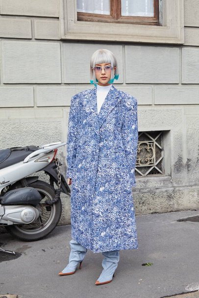 MILAN, ITALY - FEBRUARY 24, 2023: Woman with blue coat and white hair with turquoise tips with turquoise points before Philosophy by Lorenzo Serafini fashion show, Milan Fashion Week street style - Foto, Imagem