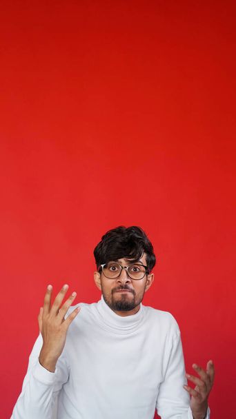 Annoyed face. Angry shrug. Stress frustration. Portrait of mad displeased man in glasses outraging on red color empty space background. - Valokuva, kuva