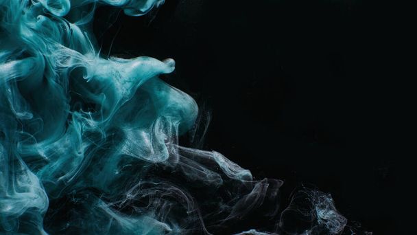 Ink water. Mist floating. Acrylic paint splash. Blue color glowing glitter fog wave on black abstract art background with copy space. - Photo, image