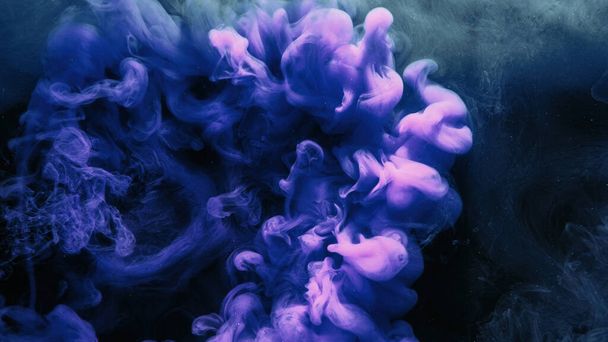 Fluid splash. Color vapor. Ink water shot. Pink blue glowing explosion smoke cloud on dark black abstract art background with free space. - Фото, изображение