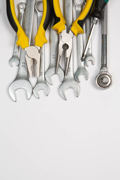 Conjunto de herramientas para la reparación en una caja sobre un fondo blanco. Surtido de herramientas de trabajo o construcción. Llaves, tenazas, destornillador. Vista superior - Foto, imagen
