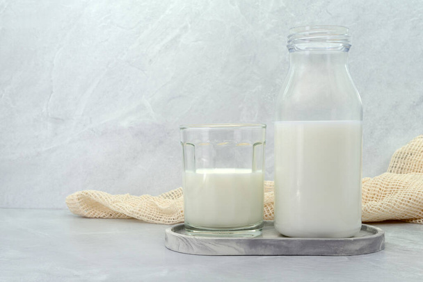 Butelka mleka i szklanka mleka na tle kamiennej tekstury. ukierunkowanie selektywne. - Zdjęcie, obraz