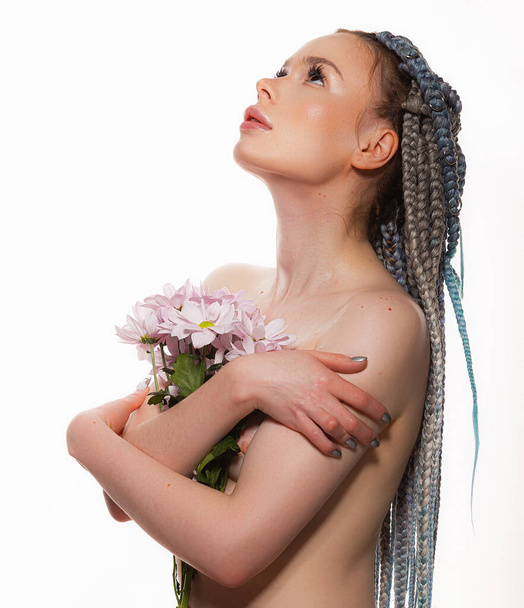 Красота портрет молодой женщины со здоровой кожей и розовыми цветами возле лица - изолированы на белом. Симпатичное лицо для здоровья или косметики - Фото, изображение