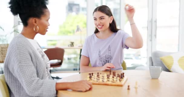 Vrienden, schaken en bordspel en schaakmat met de winnaar die lacht en nadenkt over het plan. Diversiteit vrouwen samen aan tafel in de kamer blij met concurrentie beweging en strategie om te winnen op schaakbord. - Video