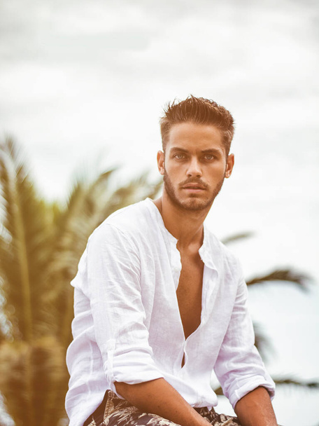 Handsome Young Man in Trendy Attire, Outdoor in Nature in a Sunny Summer Day Wearing a White Shirt - Foto, Imagen