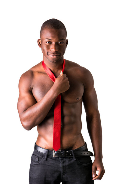 Atractivo negro joven musculoso hombre desnudo, con solo pantalones y corbata roja, aislado en blanco - Foto, Imagen