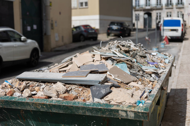 Odpady budowlane w kontenerze na ulicy. Środek strzału - Zdjęcie, obraz