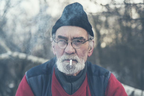Elderly man enjoying a cigarette outside - Photo, Image