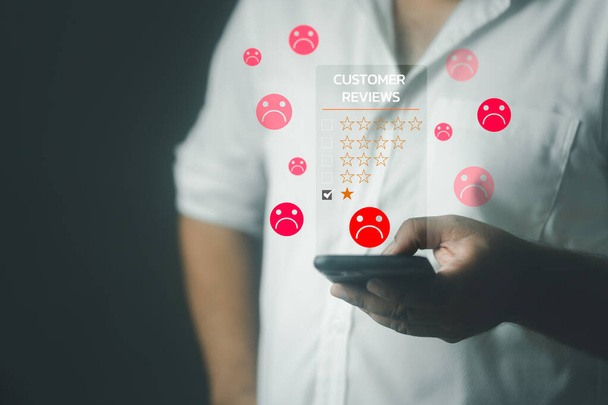 Customer experience dissatisfied concept. Unhappy man client with sadness emotion use on a smartphone give bad reviews, bad service dislike bad quality, low rating, social media not good. - Фото, изображение