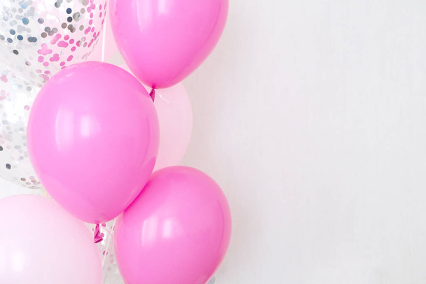 A bundle of pink and transparent air balloons with silver confetti, copy space for your text, tender pastel colors for a girlish party - Fotografie, Obrázek