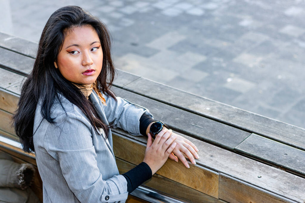 Азиатская деловая женщина с умными часами ждет - Фото, изображение