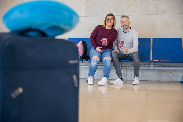 Dwóch włoskich turystów na lotnisku pokazuje paszporty, czekając na samolot. - Zdjęcie, obraz