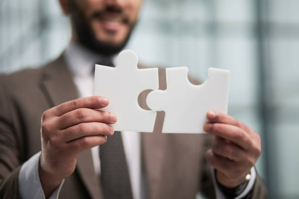 People holds in hand a jigsaw puzzle. Business solutions, success and strategy. - Photo, Image