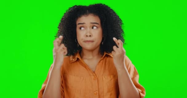 Woman, fingers crossed and pray with hope by green screen with stress on face by background. Young model girl, student and praying hands for chance, opportunity or goals with faith by studio backdrop. - Filmati, video