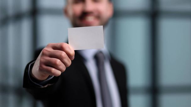 business man holding empty white business card in modern office building. Free blank copy space. - Φωτογραφία, εικόνα