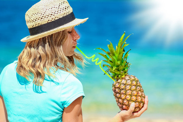 Pineapple in the hands of a man by the sea in nature on a journey background - Zdjęcie, obraz