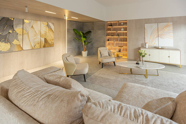 modern interior design of the living area in the studio apartment in warm soft colors. decorative built-in lighting and soft beige furniture - Foto, immagini