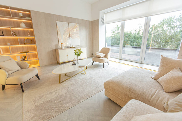 modern interior design of the living area in the studio apartment in warm soft colors. decorative built-in lighting and soft beige furniture - 写真・画像