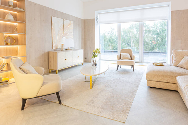 modern interior design of the living area in the studio apartment in warm soft colors. decorative built-in lighting and soft beige furniture - Φωτογραφία, εικόνα