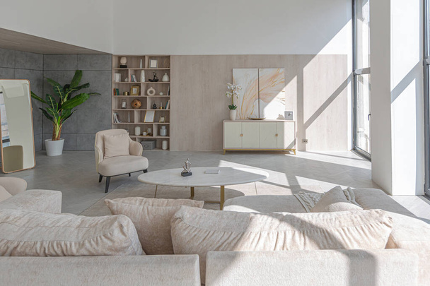 modern interior design of the living area in the studio apartment in warm soft colors. decorative built-in lighting and soft beige furniture - Fotó, kép