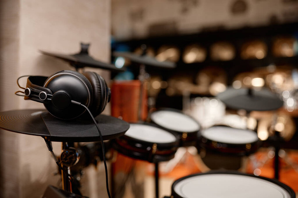 Электронная барабанная установка с наушниками. Магазин ударных музыкальных инструментов или музыкальная студия - Фото, изображение
