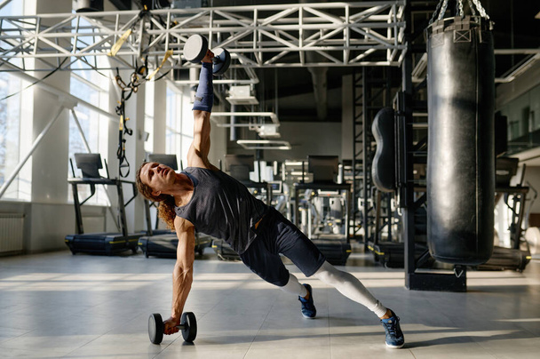 Allenamento degli sportivi muscolari con manubri pesanti che mostrano una forte potenza corporea e delle braccia perfetta. Sport palestra interno - Foto, immagini
