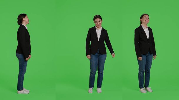 Cheerful office worker acting happy wearing suit, being friendly and stylish over full body greenscreen. Female employee feeling positive working at corporate job, studio backdrop. - Фото, зображення