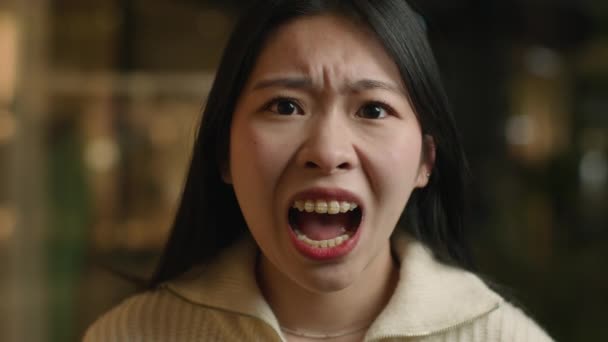 Portrait angry crazy Asian chinese woman shout open mouth shouting irritated emotion screaming aggressive japanese korean girl female scream yelling furious mad client customer feel anger stress rage - Footage, Video
