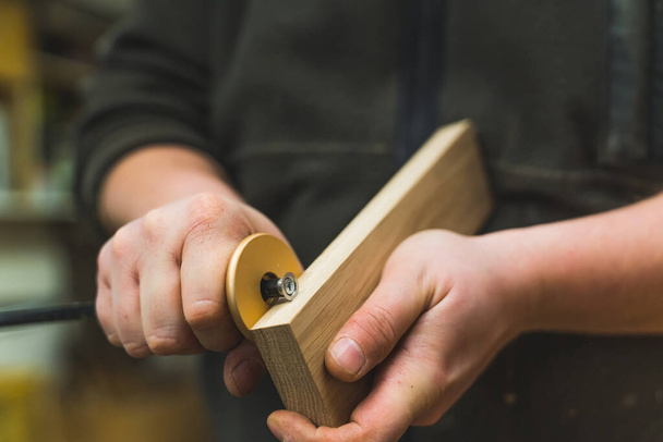 Closeup shot of adult caucasian male carpenter using marking gauge on wooden plank. Professional woodworking tool. High quality photo - Fotó, kép