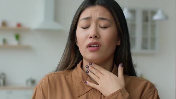 Hasta Asyalı kadın boğaz ağrısı çeken boğaz ağrısı çeken boynuna dokunuyor. Hasta kız, alerji koronavirüs enfeksiyonundan muzdarip sesini kaybediyor. Bademcik iltihabı. - Video, Çekim