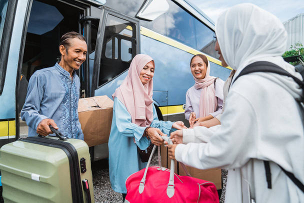 portrait of muslim family taking their parent to the bus station. eid ramadan travel concept - Photo, Image