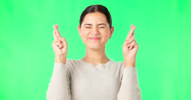 Excited woman, fingers crossed and face on green screen, background and studio for good luck. Portrait of happy female model hope for winning prize, wish and optimism with emoji sign, hands and smile. - Footage, Video