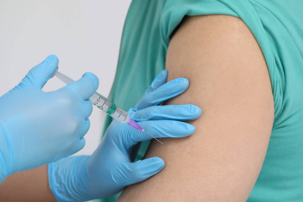 Doctor giving hepatitis vaccine to patient in clinic, closeup - Foto, imagen