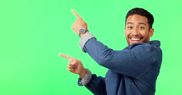 Asijský muž, ukazující a tančící na zelené obrazovce v umístění produktu nebo reklama na pozadí studia. Portrét šťastného muže ukazující gesto nebo bod pro reklamu nebo marketing na mokupství. - Záběry, video