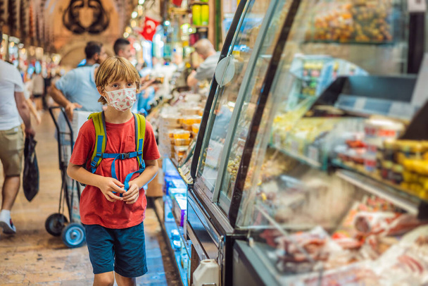 The boy looks at the counter with Turkish sweets. Traditional oriental sweet pastry cookies, nuts, dried fruits, pastilles, marmalade, Turkish desert with sugar, honey and pistachio, in display at a - Fotoğraf, Görsel