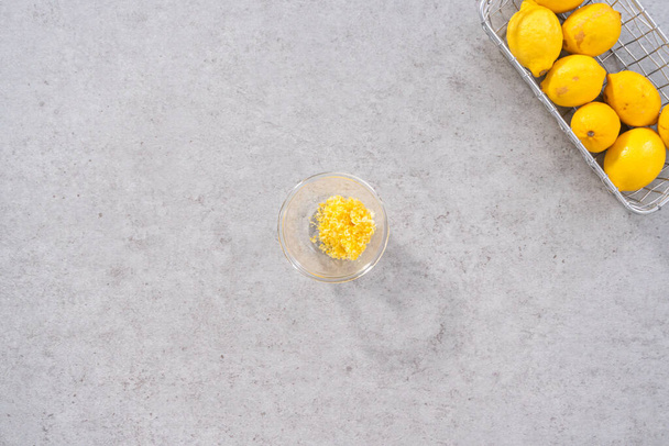Lapos fekvés. Összetevők összekeverése egy üveg keverőtálban citromos áfonyás kuglóftorta készítéséhez. - Fotó, kép
