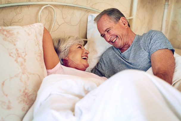 Tudod, hogy nevettess meg. egy idősebb pár, akik gyengédek a hálószobájukban. - Fotó, kép