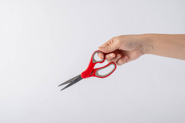 Hand holding office stationery scissors cutting on white background  - Photo, Image