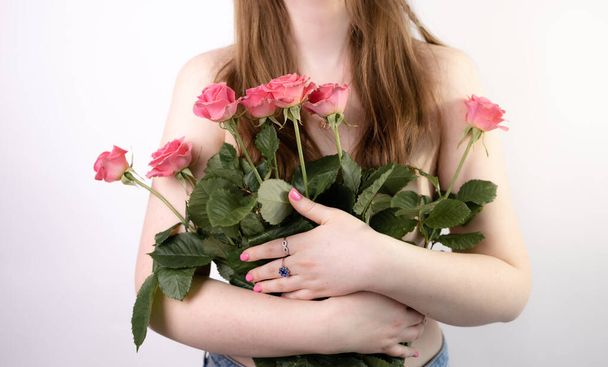 piękna młoda kobieta z bukietem róż - Zdjęcie, obraz