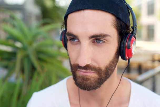 Homem com barba ouvindo música em fones de ouvido
 - Foto, Imagem