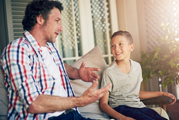 Vaderlijk advies. een vader die buiten met zijn jonge zoon praat - Foto, afbeelding
