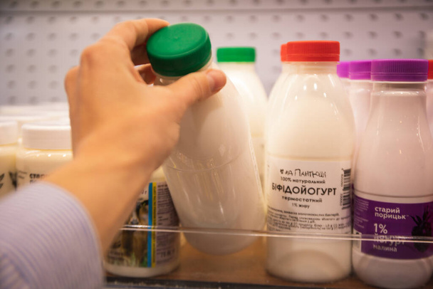 Ženská ruka vzít láhev mléčného výrobku v supermarketu - Fotografie, Obrázek